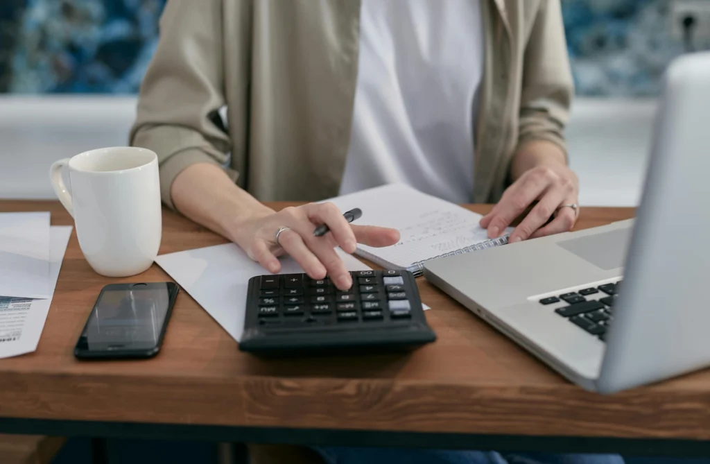 a woman making calculations when weighing the reasons to hire professionals to move your piano