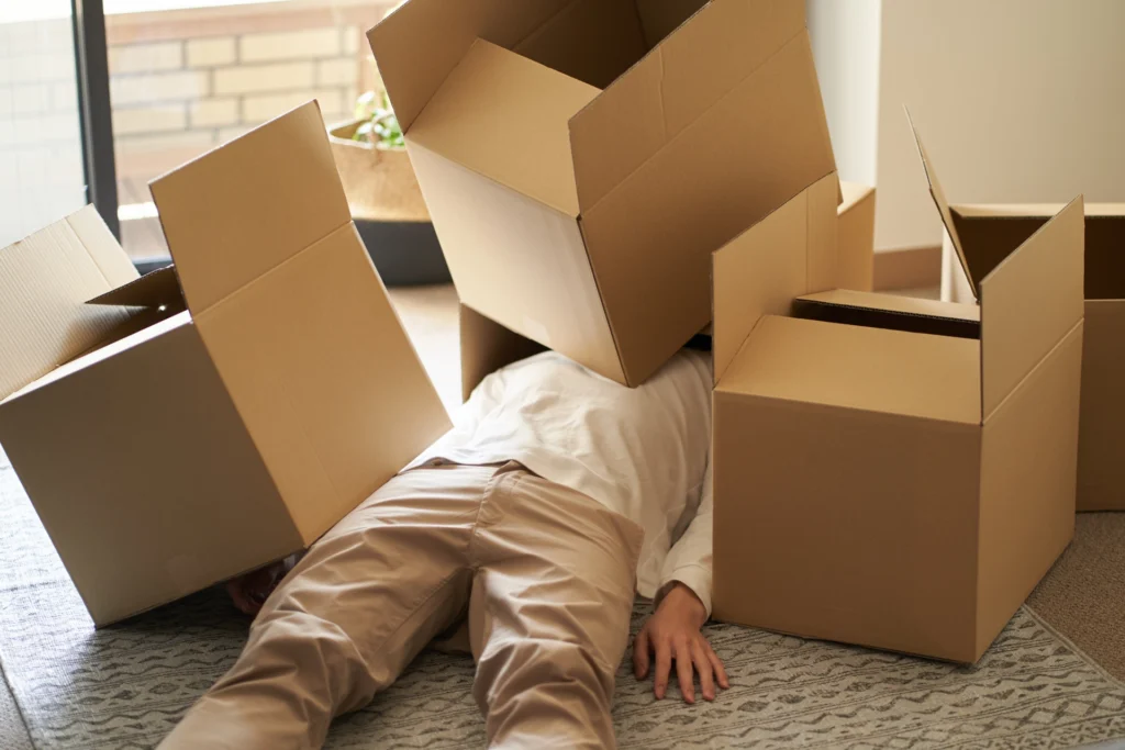 person struggling with heavy moving boxes during a DIY move in Springfield MA