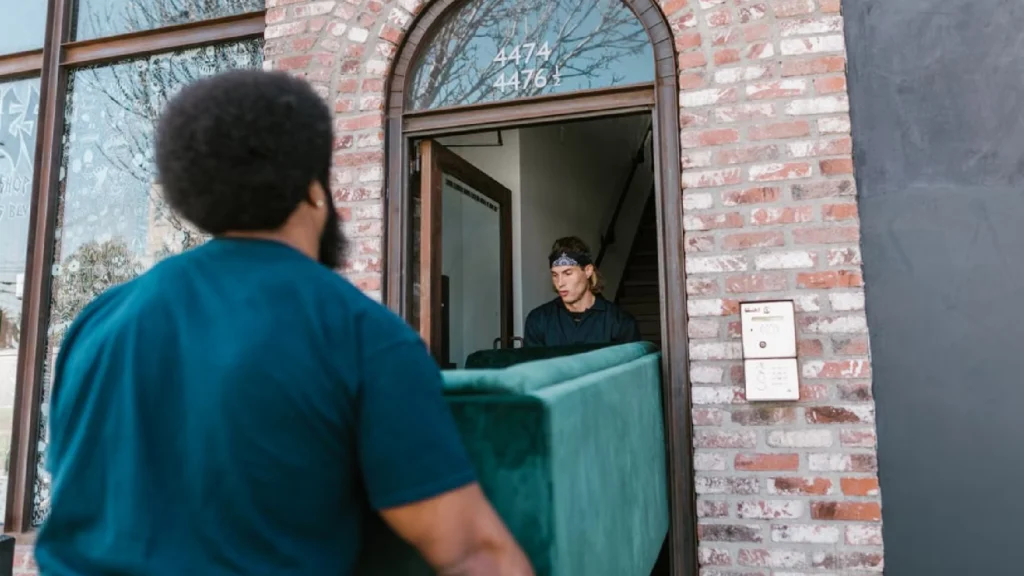 Movers carrying a couch into a building in Boston